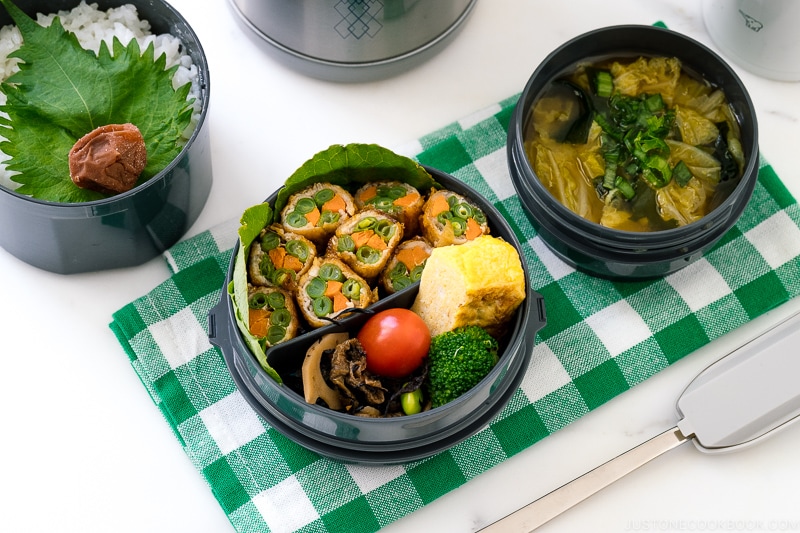 A Zojirushi lunch jar containing rice, pork rolls, and miso soup.