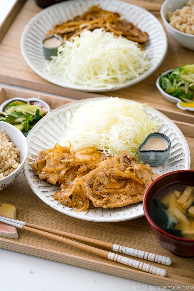 Ginger pork served with shredded cabbage on a white ceramic plate.