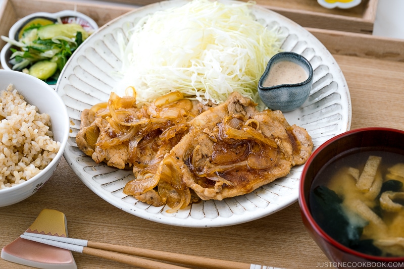 Ginger pork served with shredded cabbage on a white ceramic plate.