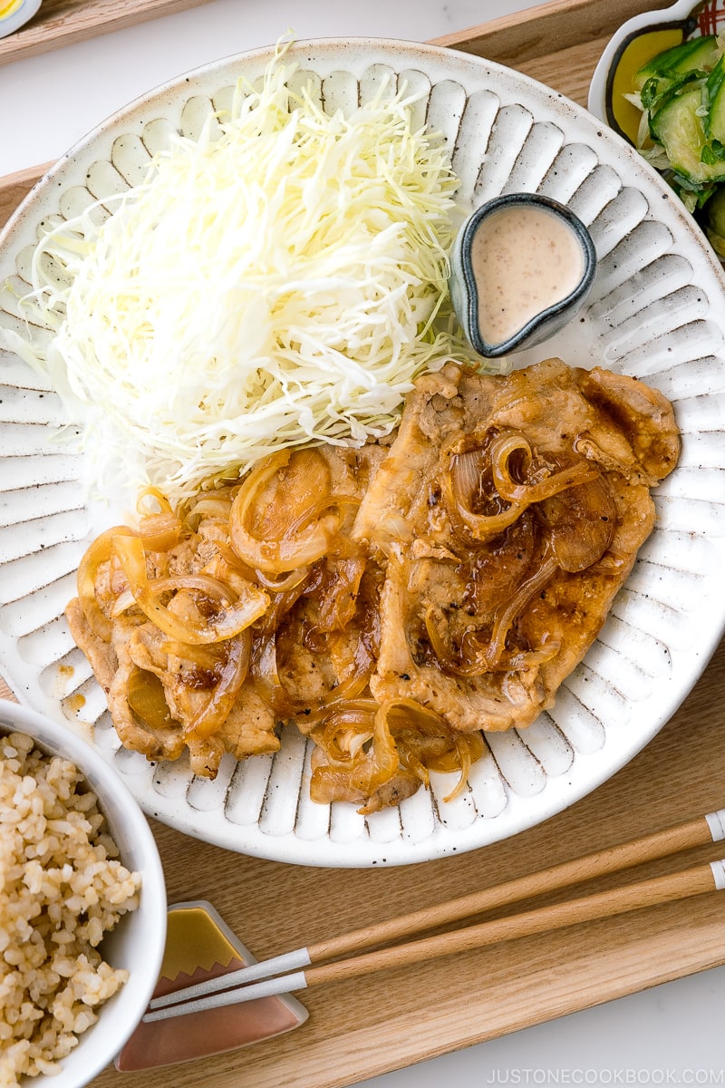 Ginger pork served with shredded cabbage on a white ceramic plate.