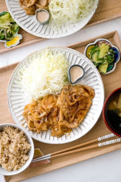 Ginger pork served with shredded cabbage on a white ceramic plate.