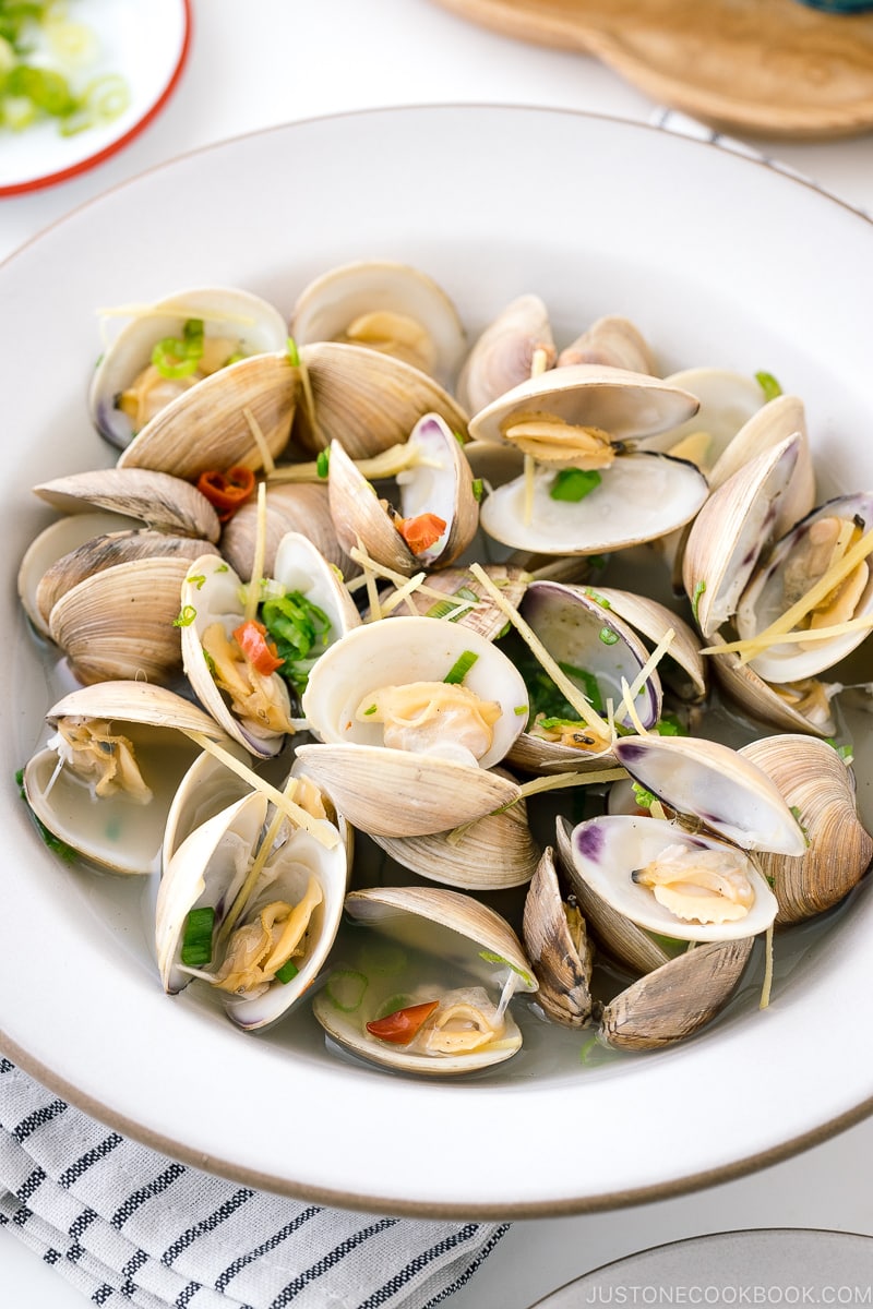 A ceramic bowl containing Japanese Sake-Steamed Clams.