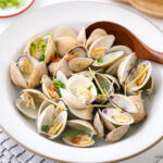 A ceramic bowl containing Japanese Sake-Steamed Clams.