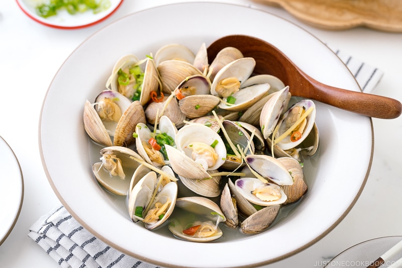 A ceramic bowl containing Japanese Sake-Steamed Clams.