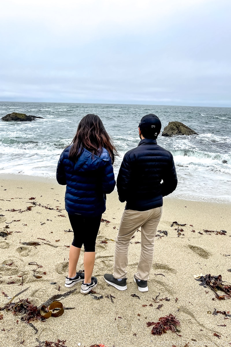 a boy and a girl standing on the beach