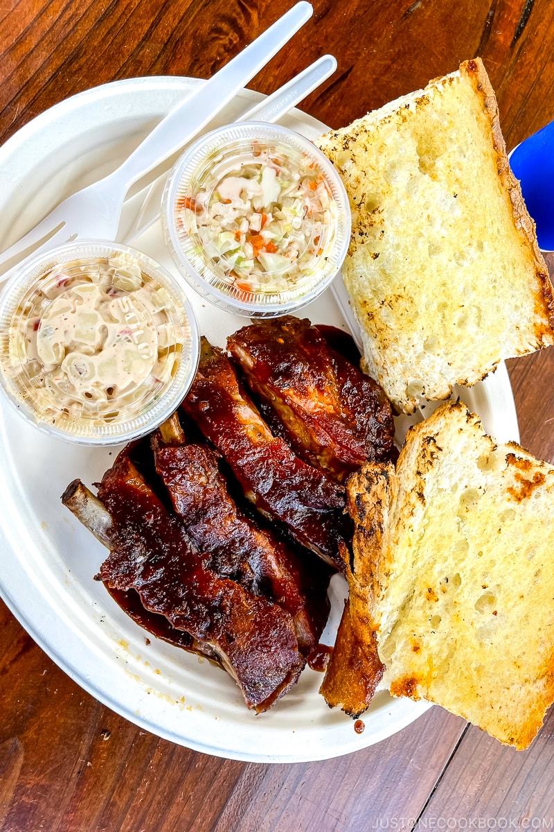 baby back ribs on a plate next to bread and cole slaw
