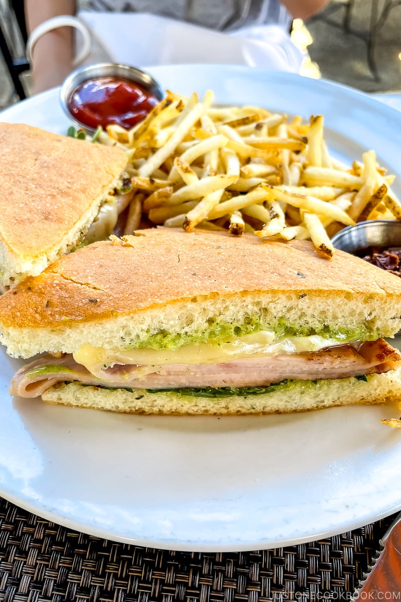 sandwich on a white plate next to french fries