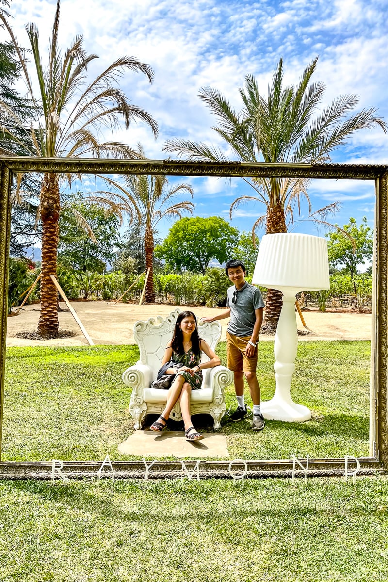 two kids behind a wood frame posing for a picture