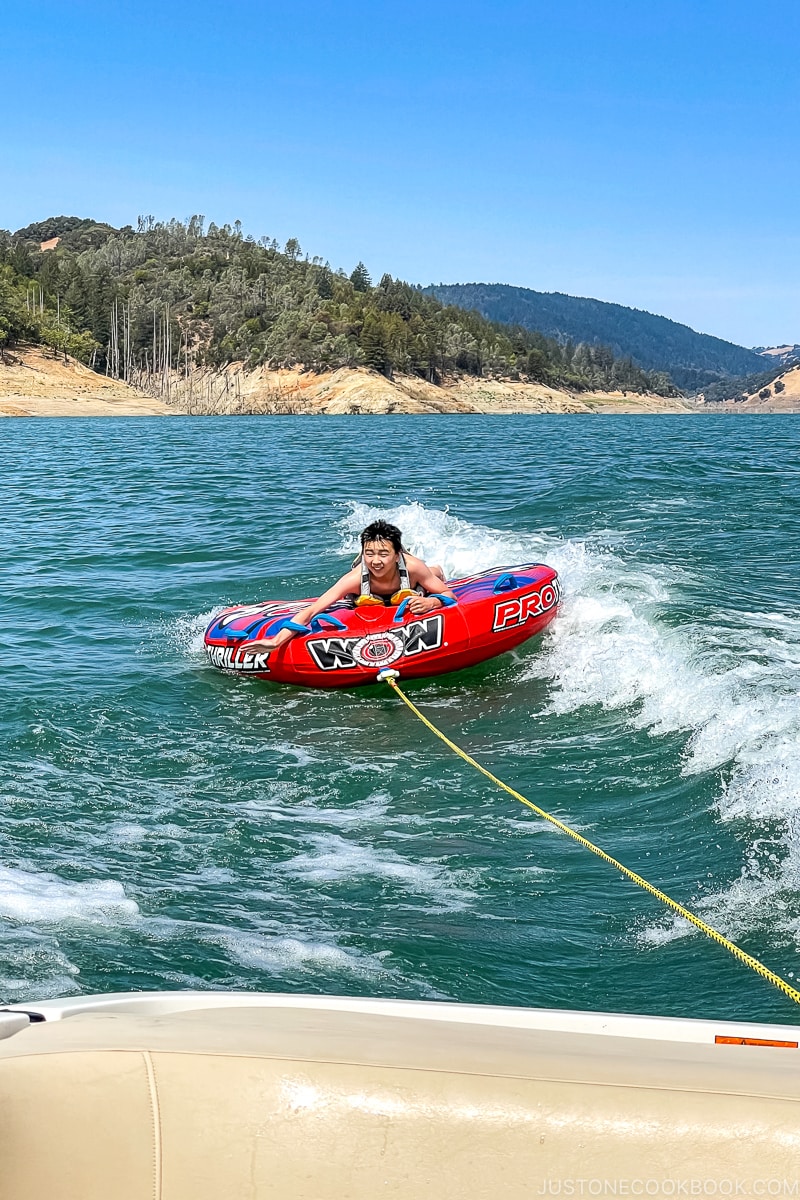 a child on a tube being dragged behind a boat