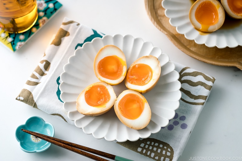 A white ceramic plate containing ramen eggs.