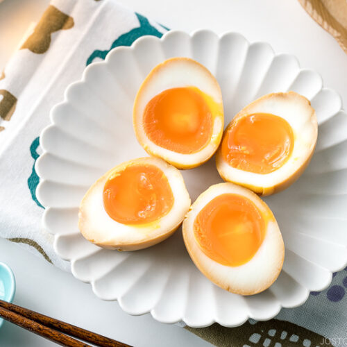 A white ceramic plate containing ramen eggs.