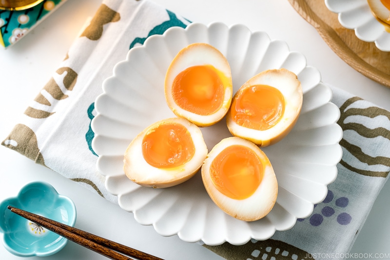 A white ceramic plate containing ramen eggs.