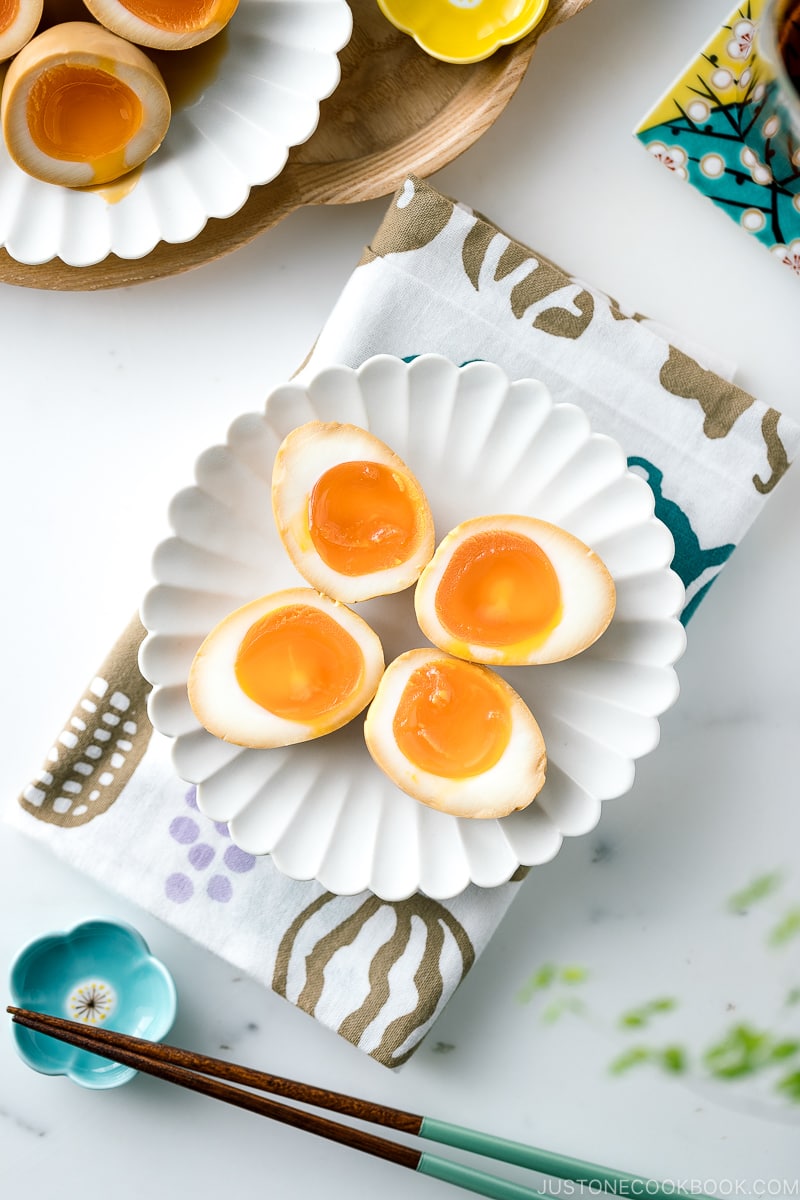 A white ceramic plate containing ramen eggs.