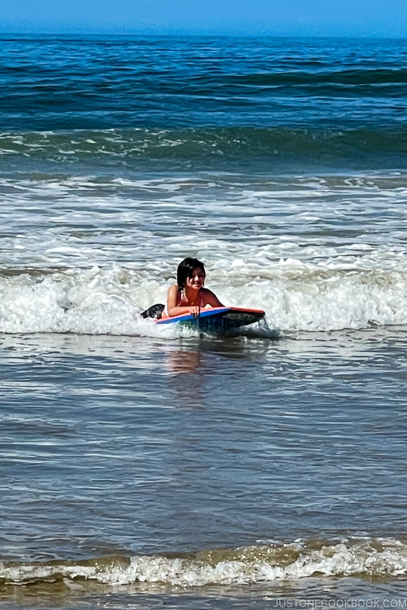 girl on boogie board in ocean
