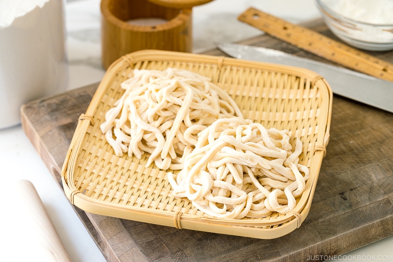 A bamboo basket containing homemade udon noodles.