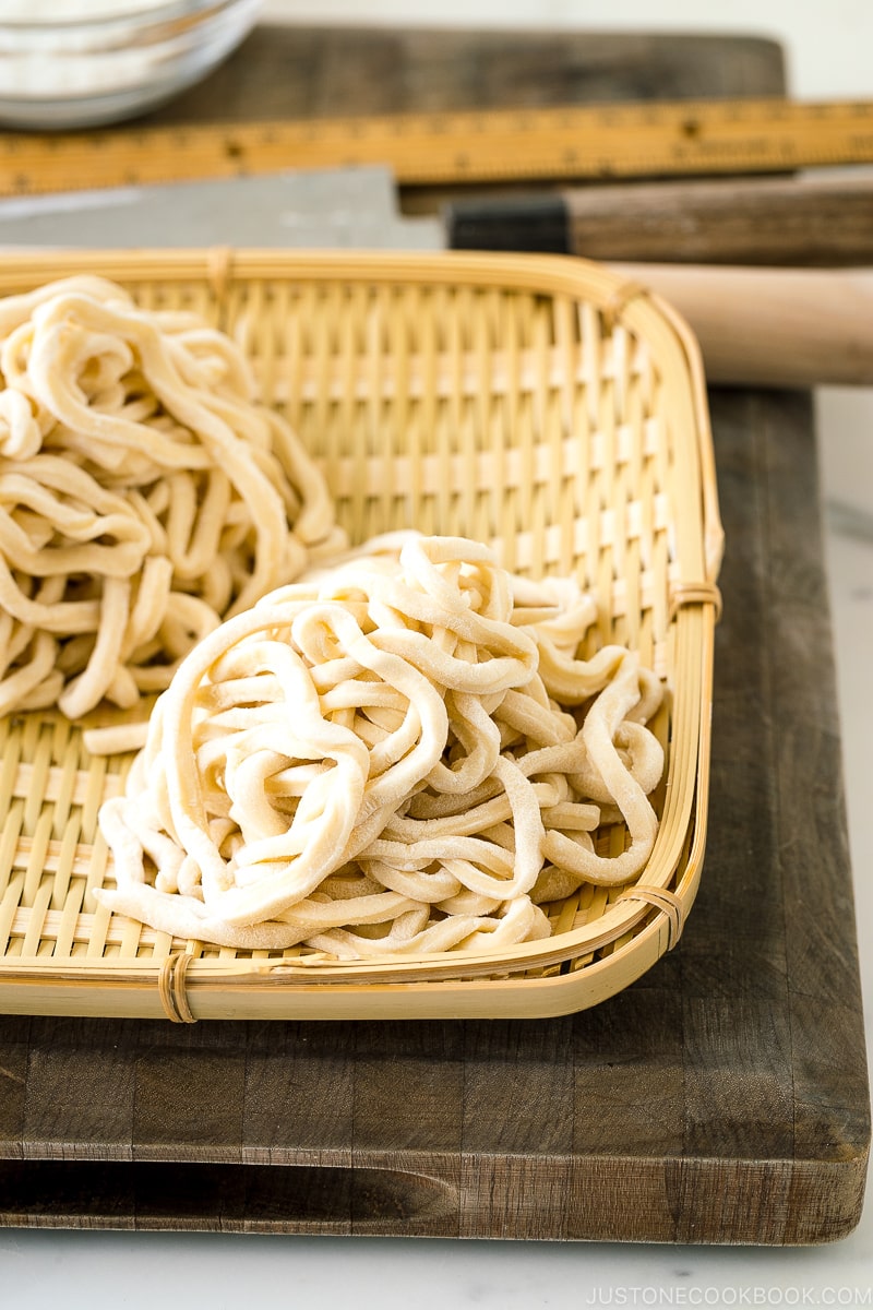 A bamboo basket containing homemade udon noodles.