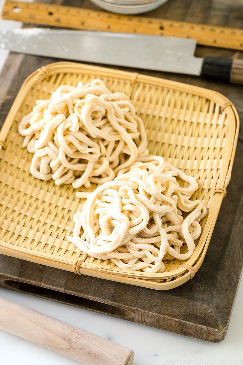 A bamboo basket containing homemade udon noodles.