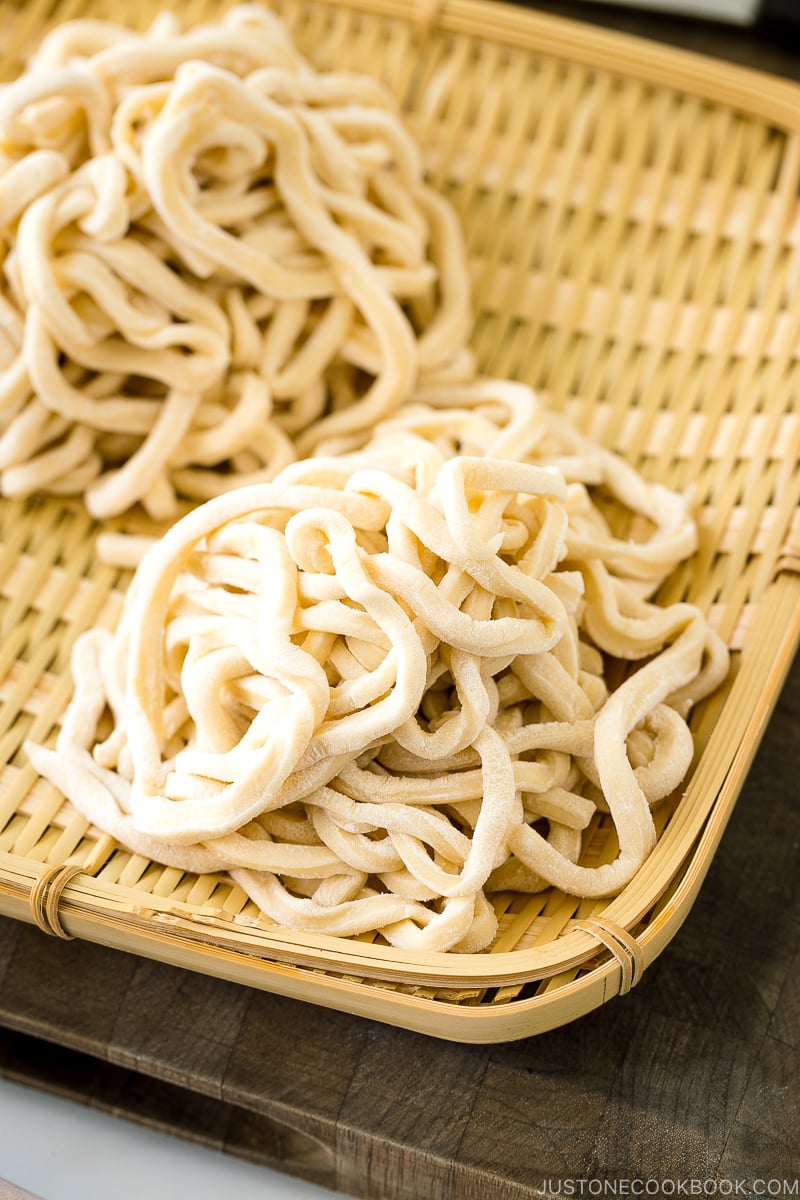 A bamboo basket containing homemade udon noodles.