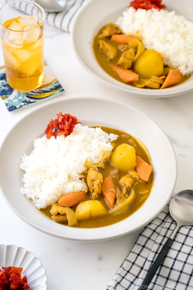 A ceramic bowl containing Japanese Chicken Curry along with steamed rice and fukujinzuke pickles.