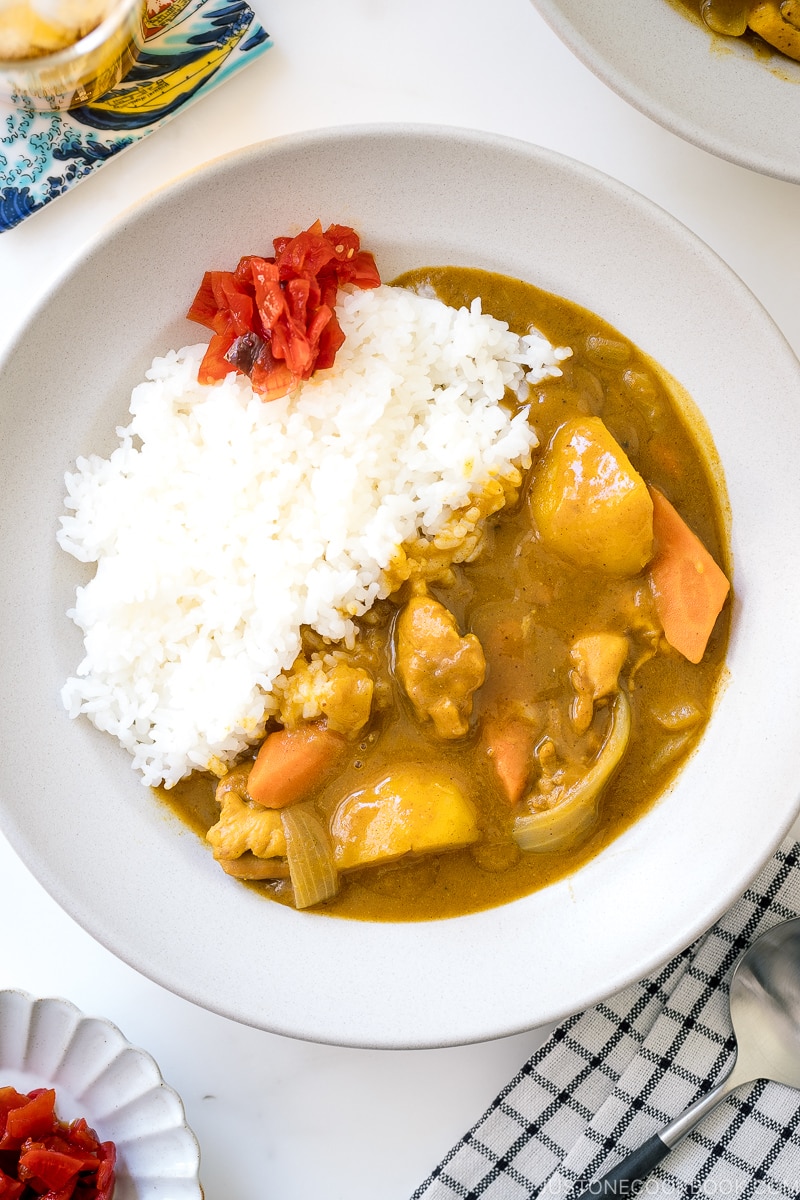 A ceramic bowl containing Japanese Chicken Curry along with steamed rice and fukujinzuke pickles.