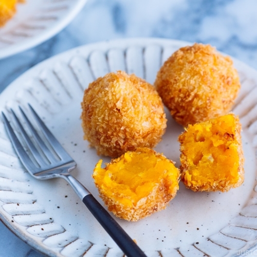 Ceramic plates containing round Kabocha Croquettes (Korokke).