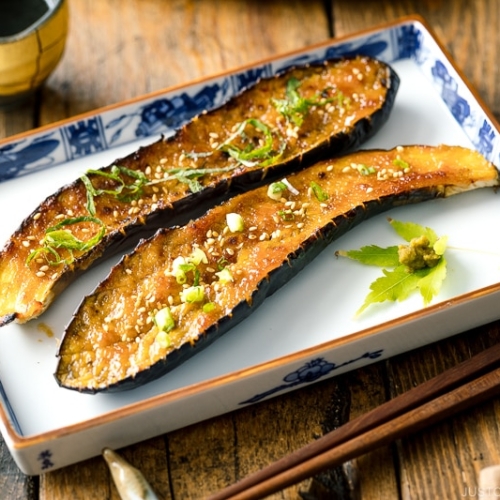 A square plate containing Miso Glazed Eggplant garnished with yuzu kosho.