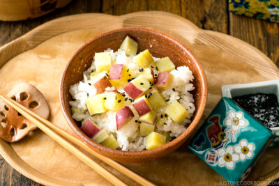 A rice bowl containing Sweet Potato Rice (Satsumaimo Gohan) sprinkled with gomashio (salt & black sesame seeds).