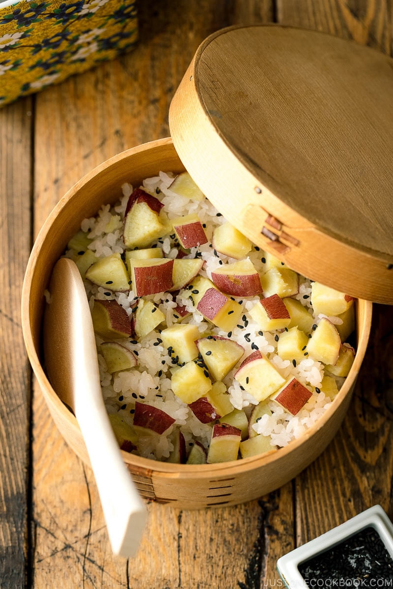 A wooden container with Sweet Potato Rice (Satsumaimo Gohan) sprinkled with gomashio (salt & black sesame seeds).