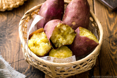 Japanese bamboo basket containing baked sweet potatoes.