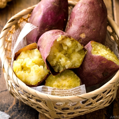 Japanese bamboo basket containing baked sweet potatoes.