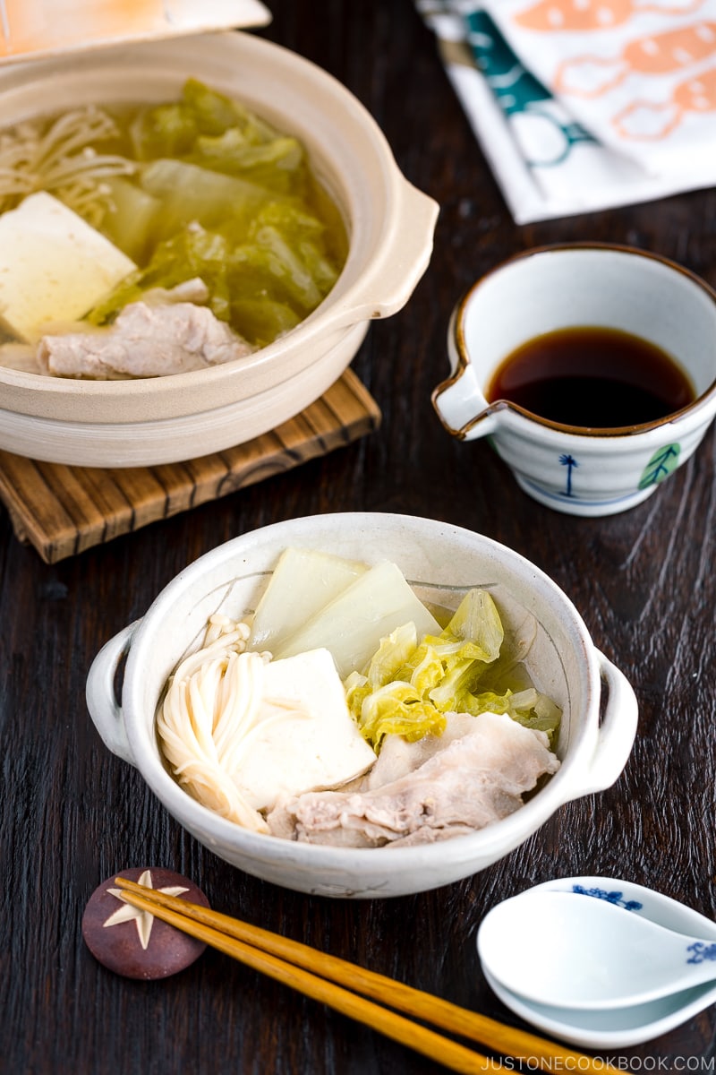 A donabe containing pork, cabbage, tofu, and mushrooms in a kombu broth.