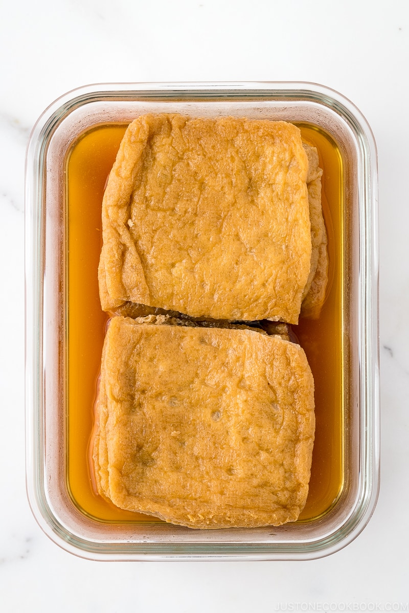 A glass container with homemade inari age.