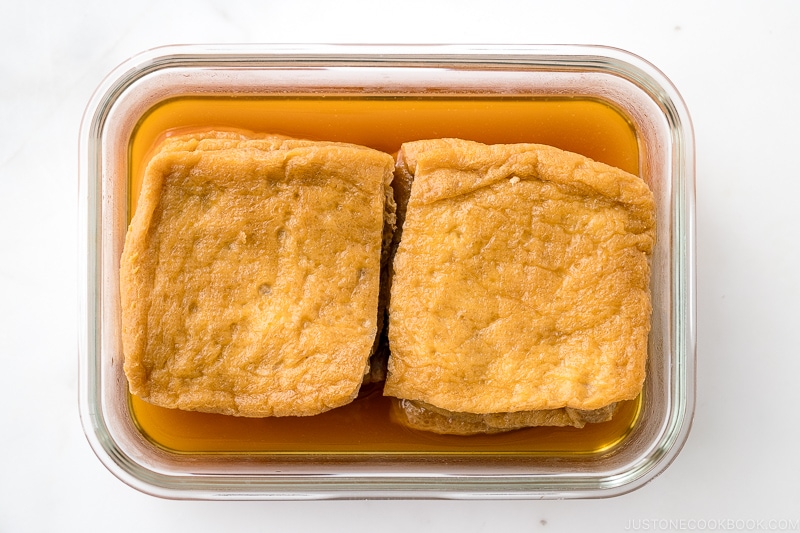 A glass container with homemade inari age.