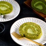 White ceramic plates containing a slice of matcha Swiss roll.