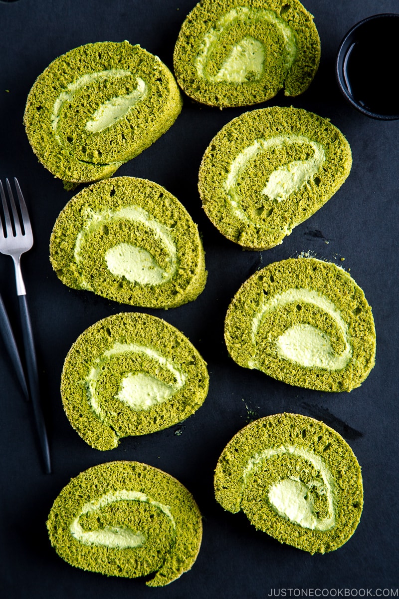 White ceramic plates containing a slice of matcha Swiss roll.