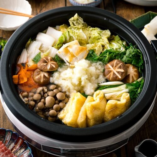 An electric hot pot containing Mizore Nabe, a Japanese hot pot with grated daikon.