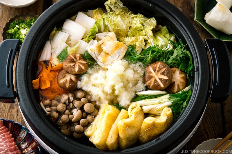 An electric hot pot containing Mizore Nabe, a Japanese hot pot with grated daikon.