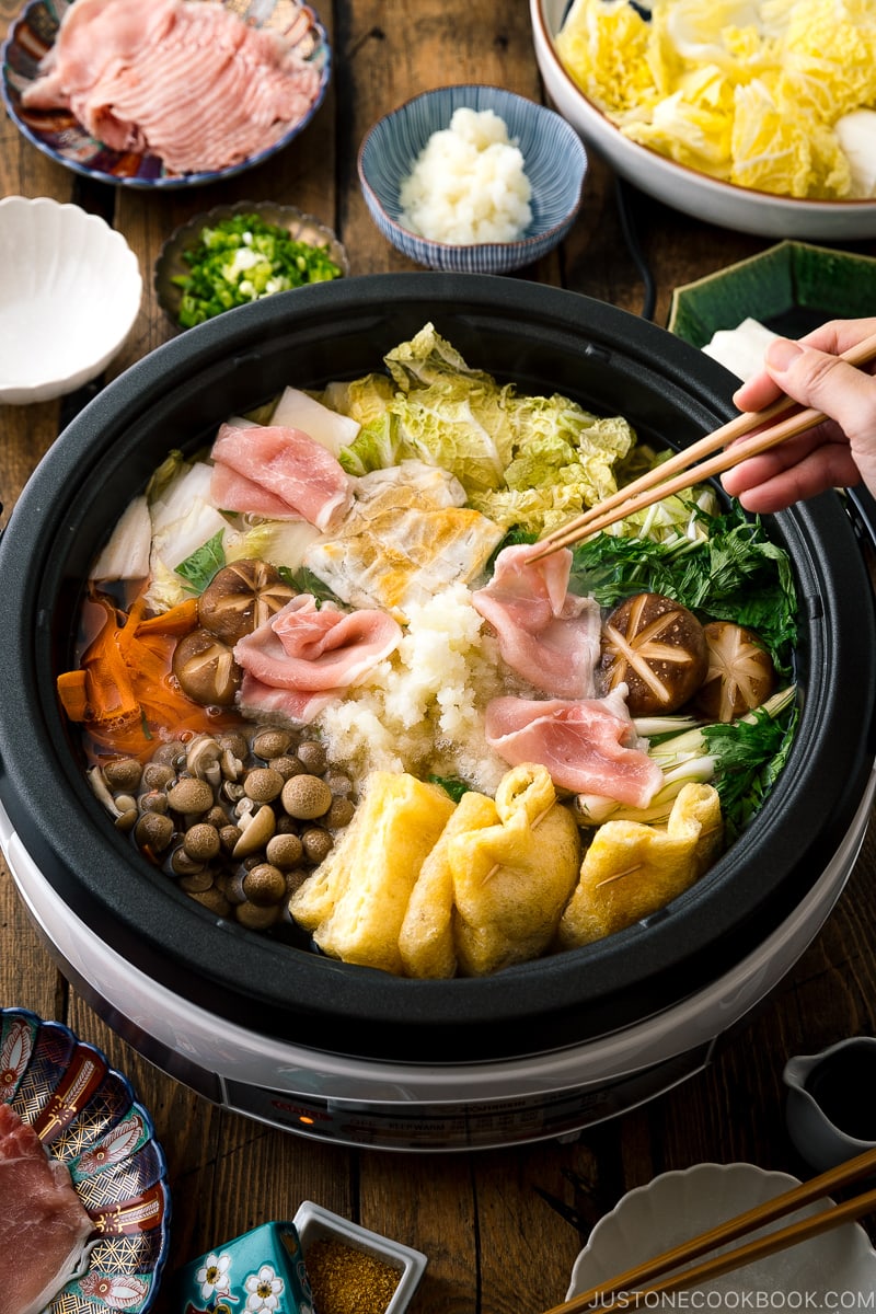 Cooking sliced pork in an electric hot pot containing Mizore Nabe, a Japanese hot pot with grated daikon.