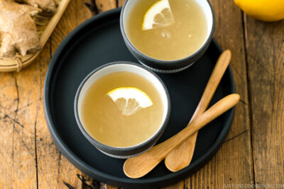 Ceramic cups containing Japanese Ginger Tea (Shogayu) garnished with a slice of lemon.