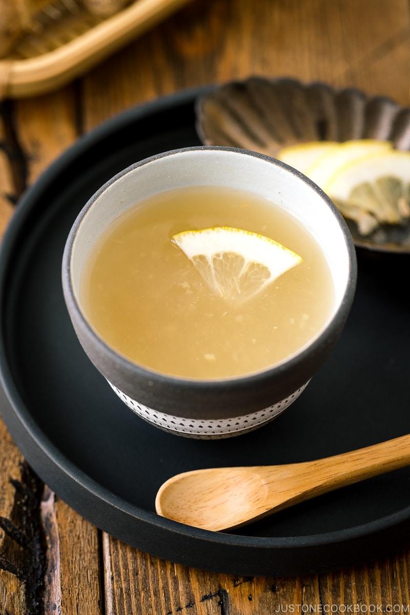 Ceramic cups containing Japanese Ginger Tea (Shogayu) garnished with a slice of lemon.