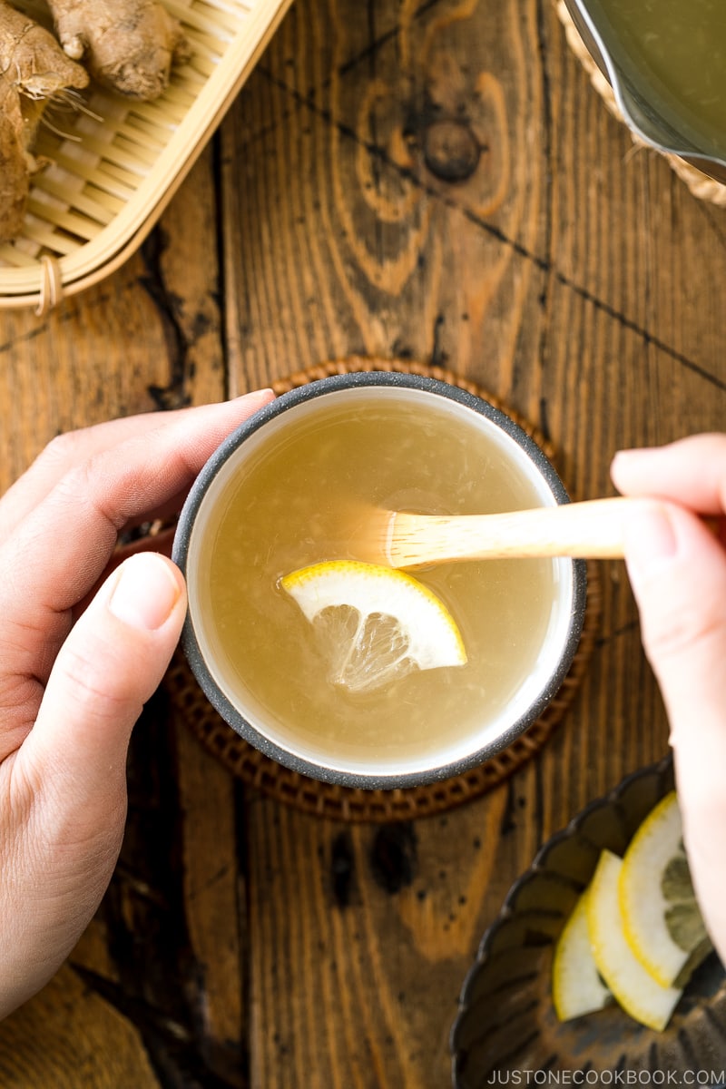 Ceramic cups containing Japanese Ginger Tea (Shogayu) garnished with a slice of lemon.