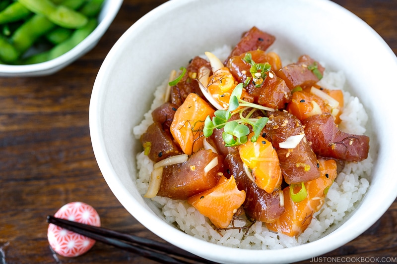 A white bowl containing tuna and salmon poke over steamed rice.
