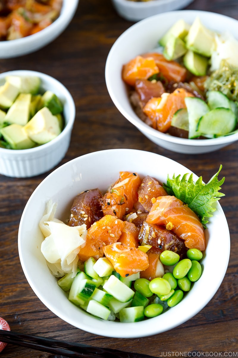 A white bowl containing tuna and salmon poke over steamed rice.
