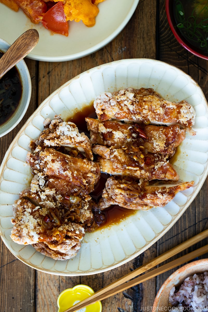 A oval plate containing Fried Chicken with Scallion Soy Sauce.