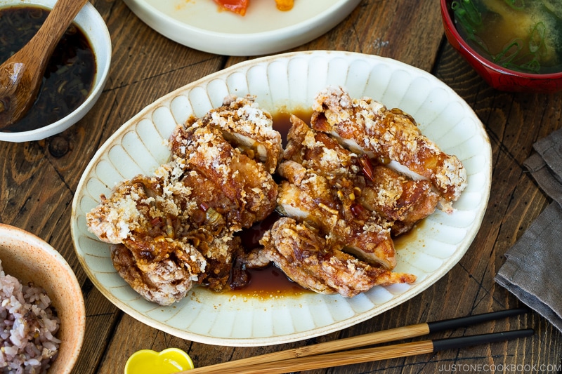 A oval plate containing Fried Chicken with Scallion Soy Sauce.