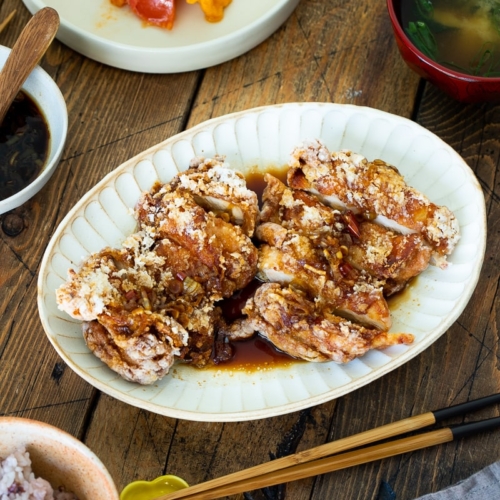 A oval plate containing Fried Chicken with Scallion Soy Sauce.