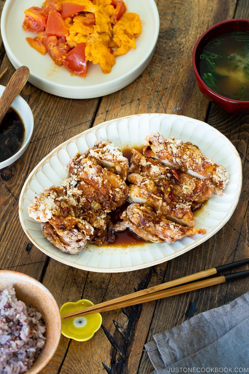 A oval plate containing Fried Chicken with Scallion Soy Sauce.