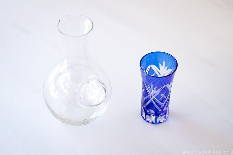 glass sake vessel and a Kiriko cup on a marble table