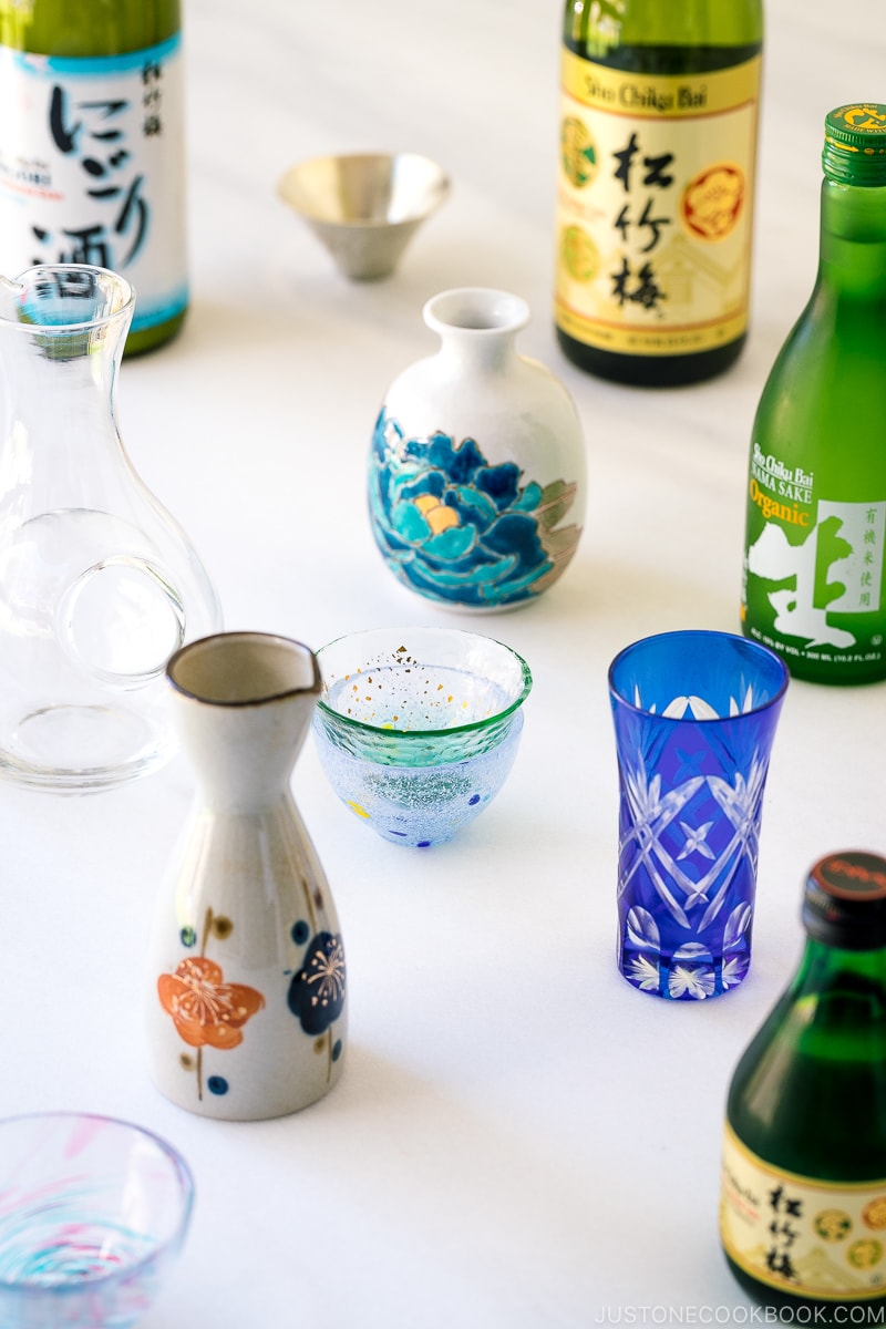 sake bottles, vessels, and cups on a marble table