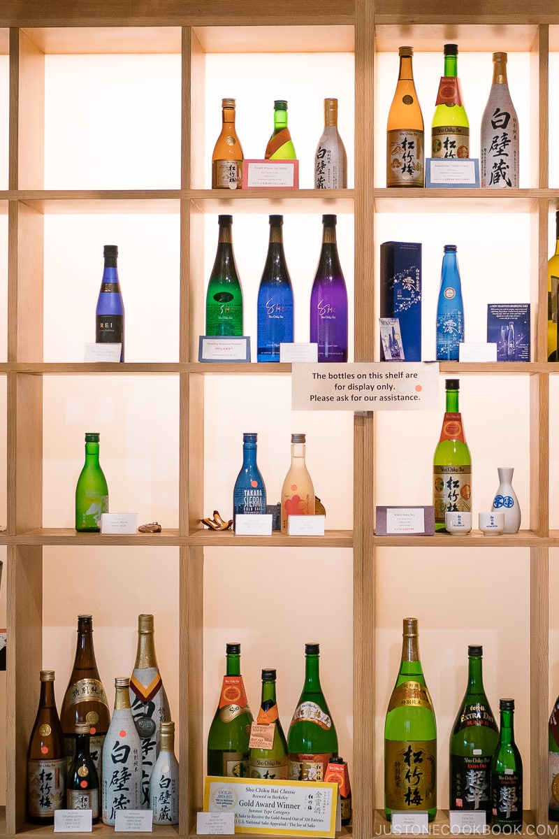 bottles of sake on wooden shelves